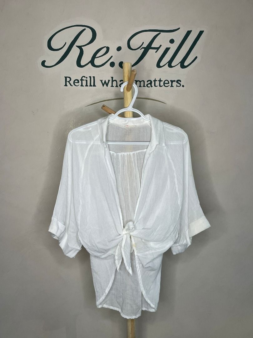 Maronie White Tie-Front Lightweight Blouse Size M (Category: Blouses) located in Taguig. Submitted by re.wear.mnl (Listing ID 1468007070, Image 1). Description: - Brand: Maronie - Size: M - Color: White - Style: Tie-front blouse with collar and 3/4 sleeves - Fabric: Lightweight and semi-sheer - Versatile: Great for casual wear or as a swimwear cover-up/layering piece - Flaw: Small yellow stain near the front tie knot (see last photo for reference