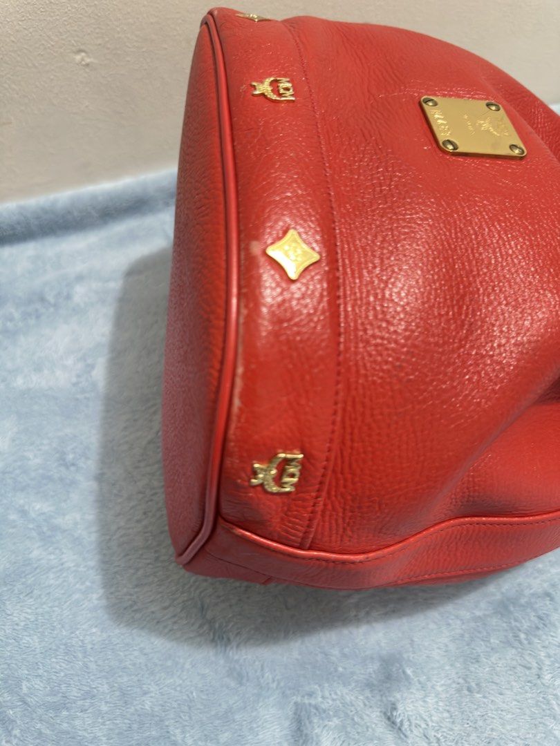 MCM Red vintage Leather Bucket Bag (Category: Tote Bags) located in Calamba. Submitted by nympha0630 (Listing ID 1467876289, Image 3). Description: - Authentic MCM bucket bag in a striking bright red pebbled leather - Features secure drawstring closure and shiny gold-tone hardware with front logo plate - Adjustable shoulder strap for comfortable wear - Bottom equipped with four protective metal feet and stylish diamond hardware - Condition: Sligh
