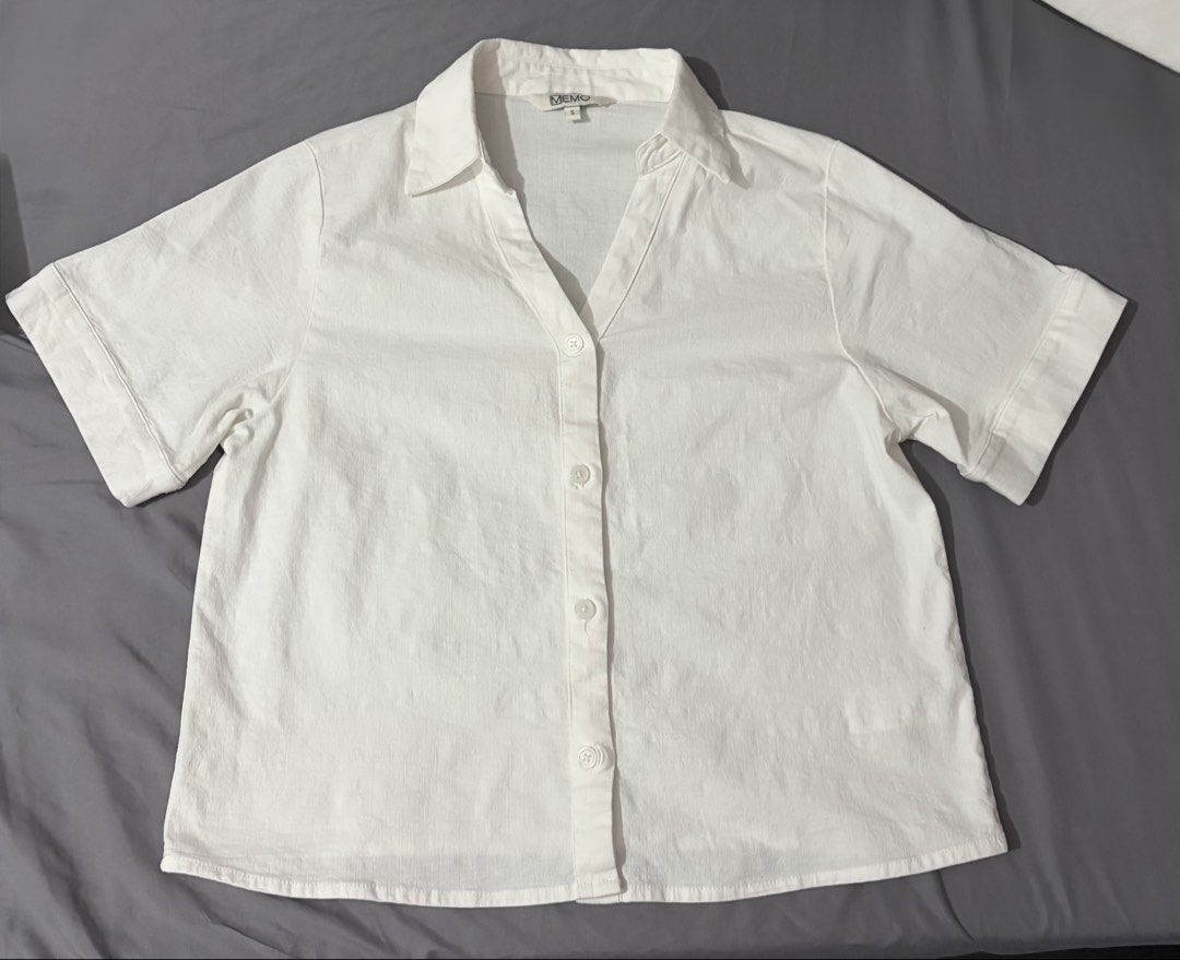 MEMO Cotton Cropped White Collared Shirt Size S (Category: Shirts) located in Taguig. Submitted by katalonia (Listing ID 1467974024, Image 1). Description: - Brand: MEMO - Color: Plain White - Style: Collared V-neck button-down with folded sleeve cuffs - Fit: Regular fit - Material: 97% Cotton, 3% Spandex - Condition: Clean, no flaws - Versatile piece, easy to pair with jeans or slacks - 45cm x 56cm - Used once only cuz too small for me. Really l