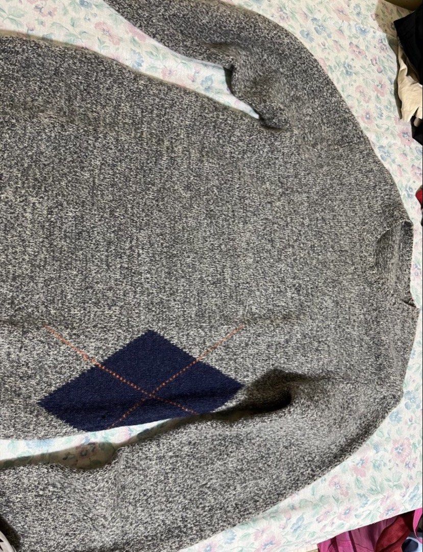 Men's Grey Argyle Crewneck Sweater - Textured Knit Pullover (Category: Coats, Jackets and Outerwear) located in Manila. Submitted by jeymzeruuu (Listing ID 1467948262, Image 3). Description: - Design - Features a classic grey heathered base with distinctive, oversized diamond (argyle) patterns in contrasting navy and burnt orange. - Style - Modern crewneck design with a comfortable, relaxed fit. - Details - The sweater showcases intricate knit te