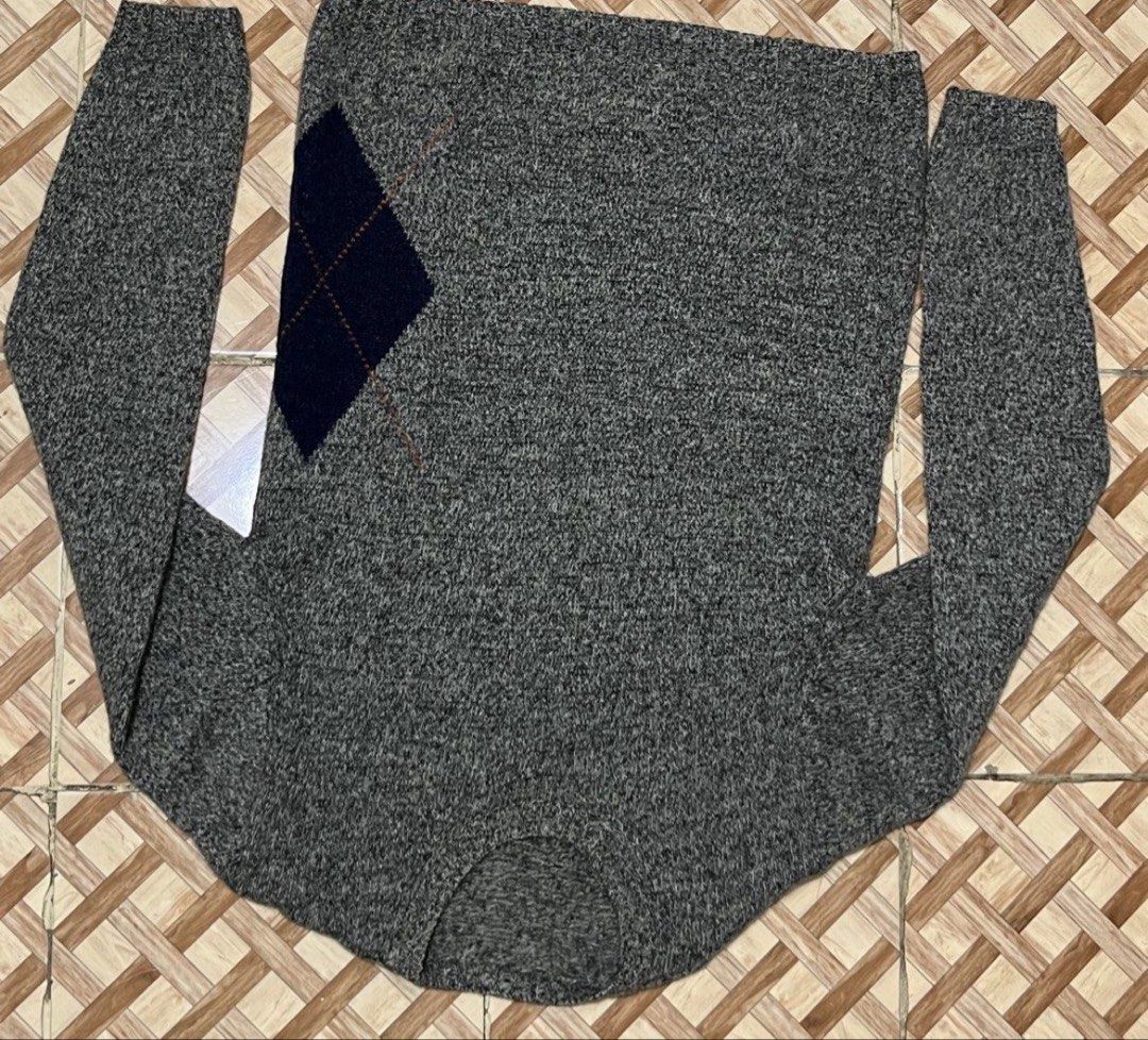 Men's Grey Argyle Crewneck Sweater - Textured Knit Pullover (Category: Coats, Jackets and Outerwear) located in Manila. Submitted by jeymzeruuu (Listing ID 1467948262, Image 2). Description: - Design - Features a classic grey heathered base with distinctive, oversized diamond (argyle) patterns in contrasting navy and burnt orange. - Style - Modern crewneck design with a comfortable, relaxed fit. - Details - The sweater showcases intricate knit te