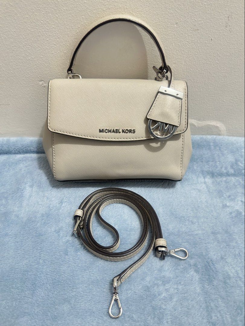 Michael Kors Ava Mini Crossbody Bag (Category: Cross-body Bags) located in Calamba. Submitted by nympha0630 (Listing ID 1467875173, Image 1). Description: - Brand: Michael Kors - Material: Durable Saffiano leather in versatile off-white - Hardware: Silver-tone with chic front flap turnlock charm - Exterior: Structured rectangular shape with flat base and back slip pocket - Interior: Fabric-lined with 1 zipper pocket and 1 slip pocket - Strap: Com
