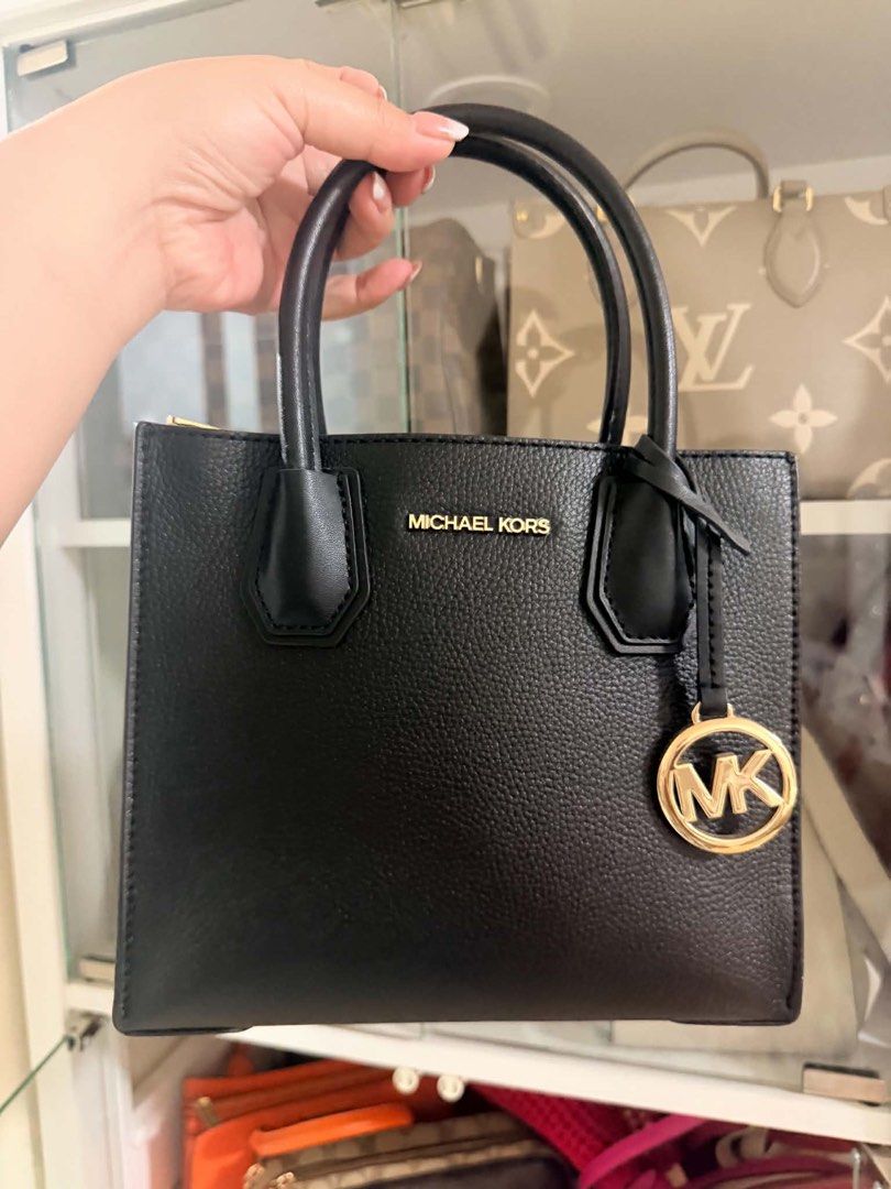 Michael Kors Black Leather Tote Bag (Category: Tote Bags) located in Manila. Submitted by carlajoyce (Listing ID 1468051097, Image 1). Description: - Brand: Michael Kors - Material: Premium black pebble leather with clean grain texture - Hardware: Elegant gold lettering on the front - Accents: Matching circular MK charm dangling from the handle - Design: Structured shape with twin top handles - Condition: Excellent, ready to use.
