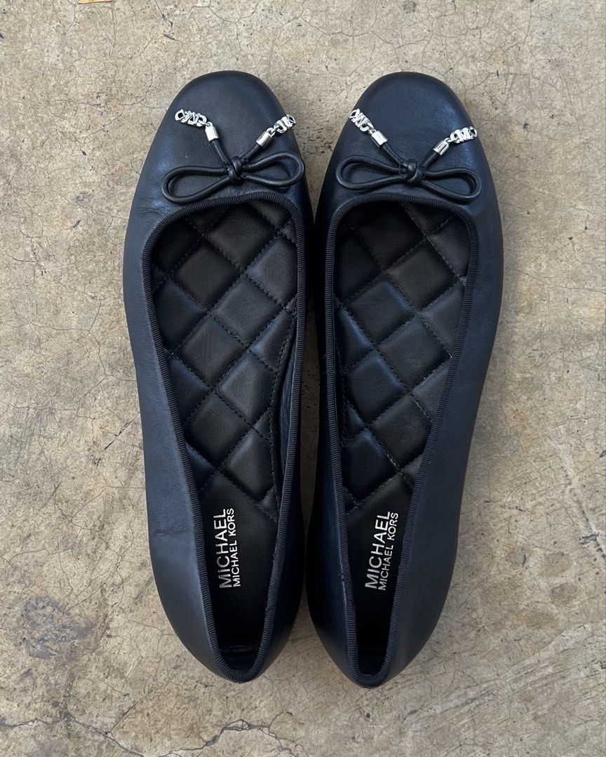 Michael Kors Black Quilted Ballet Flats with Bow (Category: Flats & Sandals) located in Malita. Submitted by happy_duckling (Listing ID 1467846534, Image 1). Description: - Brand: Michael Kors - Style: Black leather ballet flats with round toe and slip-on design - Details: Cute front bow tie with silver-tone MK charms and quilted diamond inner sole - Condition: Clean black leather upper with light scuffing on the soles from normal walking - Perfe