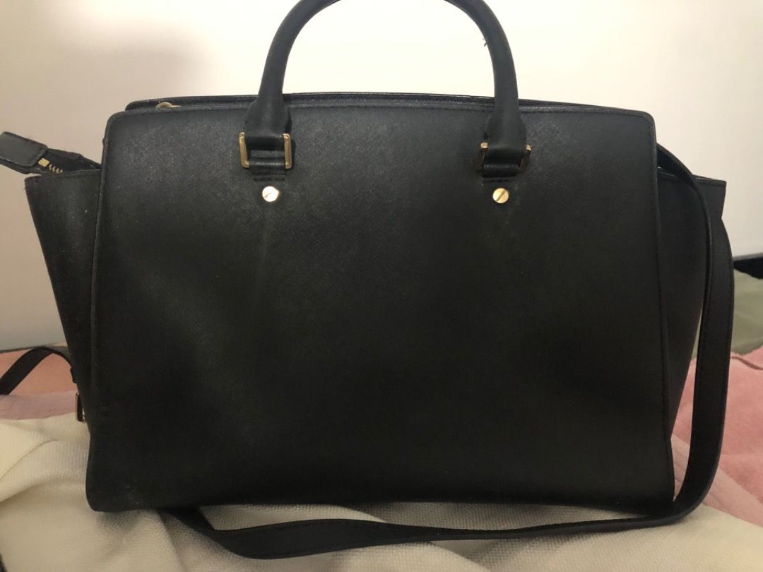 Michael Kors Black Satchel Handbag (Category: Luxury Bags & Wallets) located in Manila. Submitted by kissa.1890 (Listing ID 1468045910, Image 2). Description: - Brand: Michael Kors - Material: Premium black leather - Hardware: Gold-tone with centered front logo - Handles/Strap: Double top handles and a detachable shoulder strap - Closure: Secure zip-top closure - Condition: Clean interior with minimal signs of wear on the exterior structure - Cap