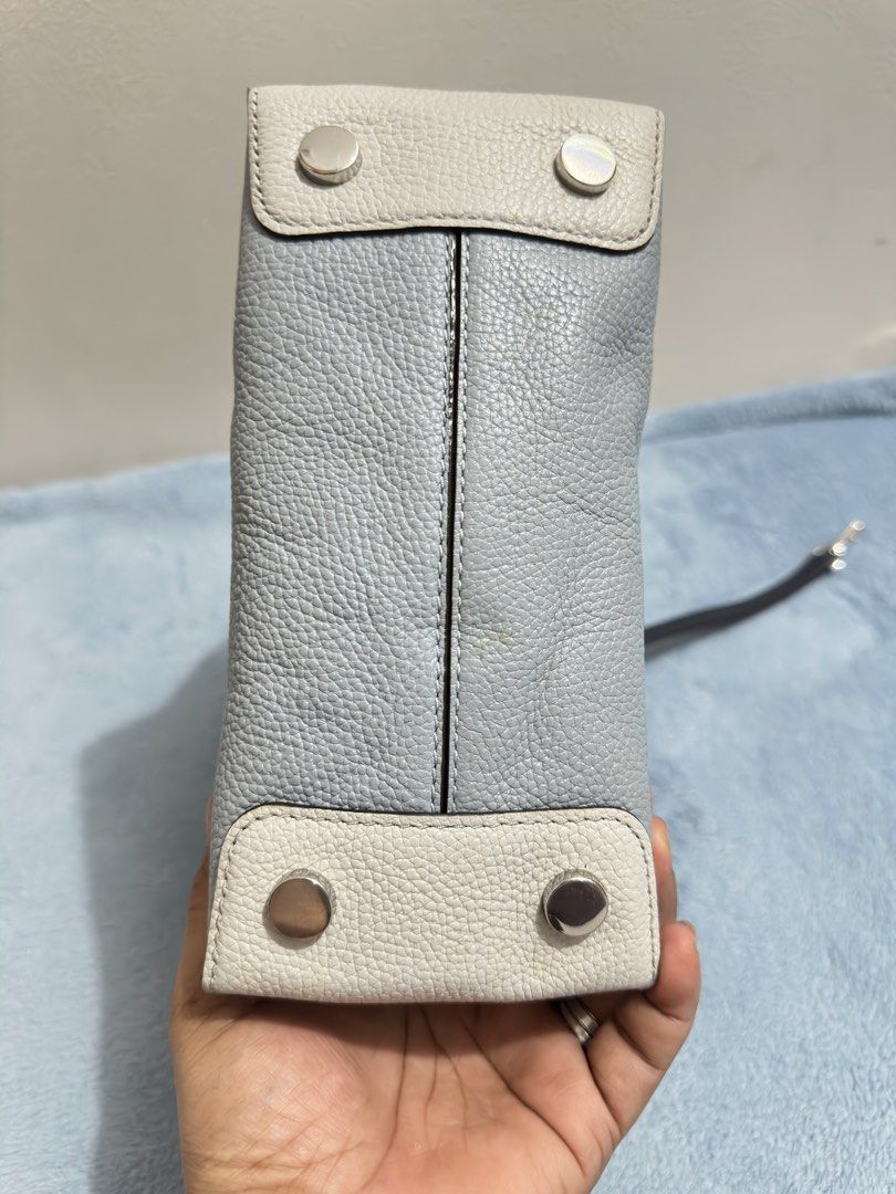 Michael Kors Mercer Mini Light Blue Navy (Category: Tote Bags) located in Calamba. Submitted by nympha0630 (Listing ID 1467853955, Image 3). Description: - Brand: Michael Kors - Style: Mini Tote Bag - Color: Light blue with navy blue handles - Material: Premium pebbled leather - Hardware: Silver-tone with front padlock charm - Strap: Includes detachable crossbody strap - Base: Protective bottom feet - Handles: Dual top carry handles - Interior: C