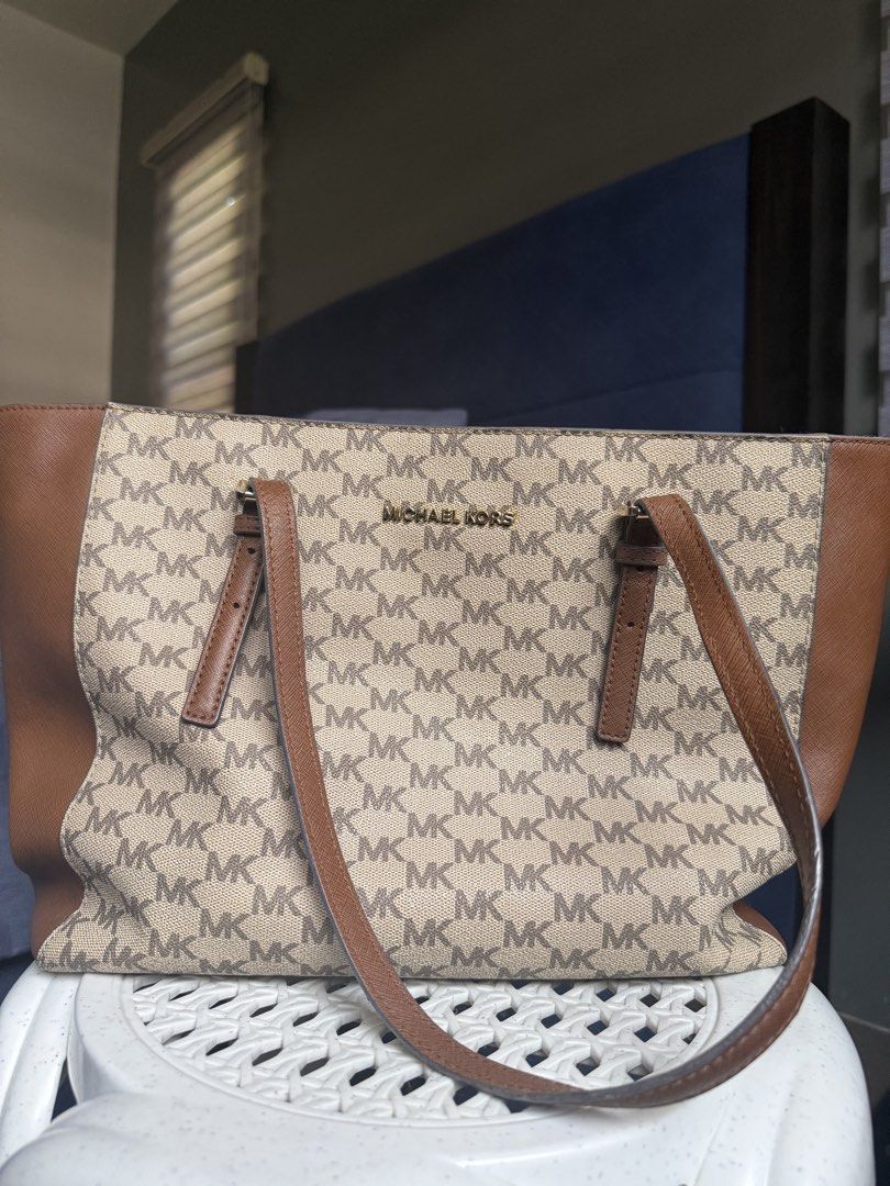 Michael Kors MK Monogram Brown Tote Bag (Category: Tote Bags) located in Davao. Submitted by ishtaranne (Listing ID 1467885939, Image 1). Description: - Authentic Michael Kors tote bag in classic brown and tan monogram print - Durable Saffiano leather trim and comfortable dual straps - Secure zip-top closure with elegant gold-tone hardware and front logo lettering - Spacious fabric-lined interior featuring a middle zip compartment and multiple sl