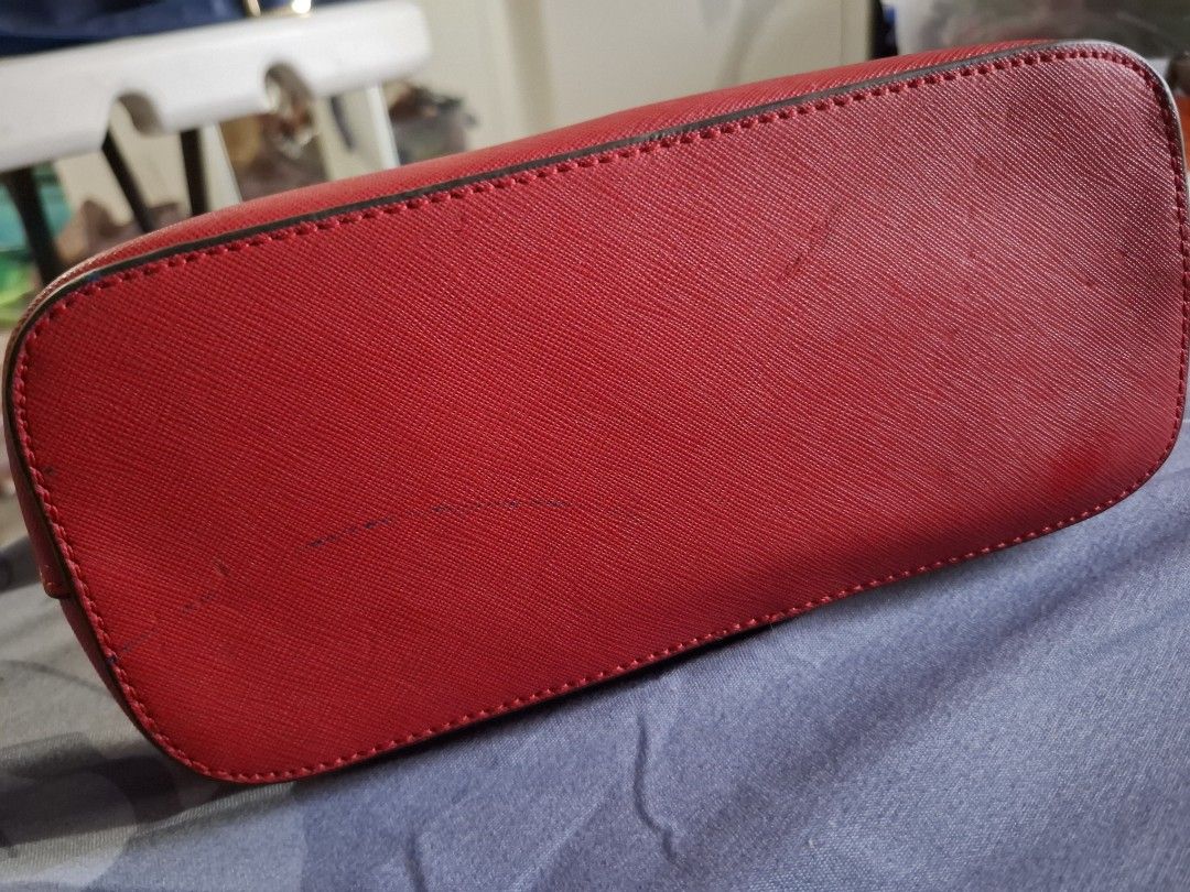 Michael Kors Red Dome Crossbody Bag (Category: Cross-body Bags) located in Marikina City. Submitted by bags21.ph (Listing ID 1467840283, Image 2). Description: - Brand: Michael Kors - Material: Textured Saffiano leather in bright red - Hardware: Gold-tone with front metal logo lettering - Strap: Adjustable with a stylish chain-link section - Closure & Interior: Zip top closure, fabric logo lining, slip pocket, and zipper pocket - Condition: Good 