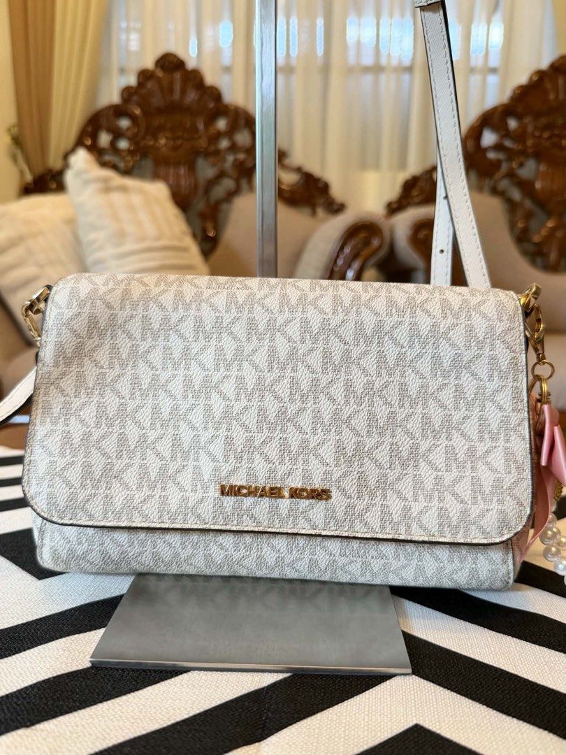 Michael Kors White MK Monogram Crossbody Bag (Category: Cross-body Bags) located in Santiago. Submitted by yrellagnoihsaf (Listing ID 1467851499, Image 2). Description: Michael Kors Medium Logo Convertible Crossbody Bag in the vanilla print pattern. ✅ AUTHENTIC ✅ ALMOST NEW MINIMAL SIGNS OF USAGE ✅ L 79” H 6” W 2” ✅ BODY BAG ADJUSTABLE STRAP ❤️accessories not included Pm me for details ❣️❣️❣️ .