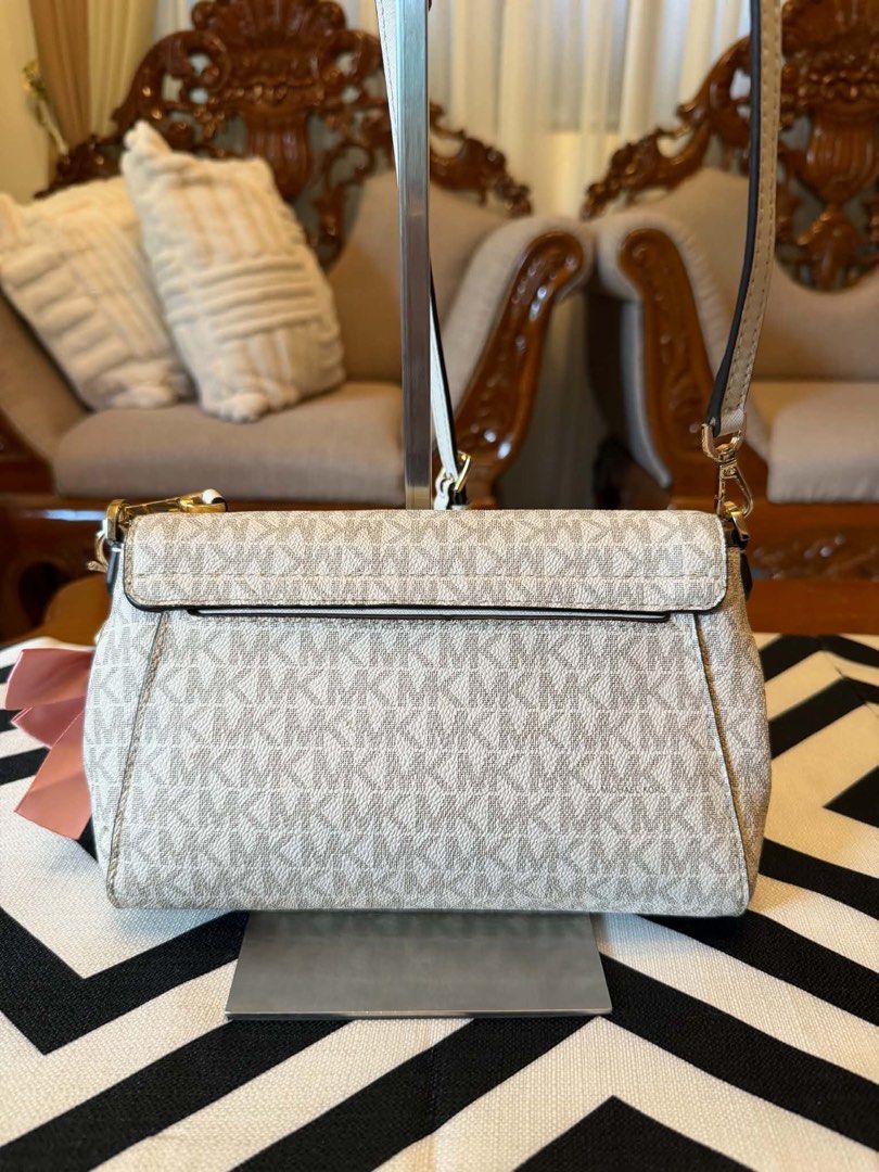 Michael Kors White MK Monogram Crossbody Bag (Category: Cross-body Bags) located in Santiago. Submitted by yrellagnoihsaf (Listing ID 1467851499, Image 3). Description: Michael Kors Medium Logo Convertible Crossbody Bag in the vanilla print pattern. ✅ AUTHENTIC ✅ ALMOST NEW MINIMAL SIGNS OF USAGE ✅ L 79” H 6” W 2” ✅ BODY BAG ADJUSTABLE STRAP ❤️accessories not included Pm me for details ❣️❣️❣️ .