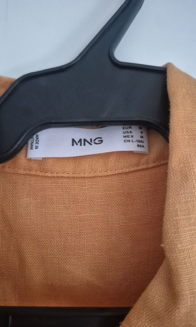 MNG Yellow Linen Button Shirt Size M (Category: Blouses) located in Taguig. Submitted by declutter_it420 (Listing ID 1467736136, Image 3). Description: - Brand: Mango - Size: Medium (M) - Color: Oranfe - Material: Lightweight linen, ideal for warm weather - Style: Classic collar with front button-down closure - Condition: Clean, excellent, and ready to wear -Versatility: Can be worn for the office or casual outings.