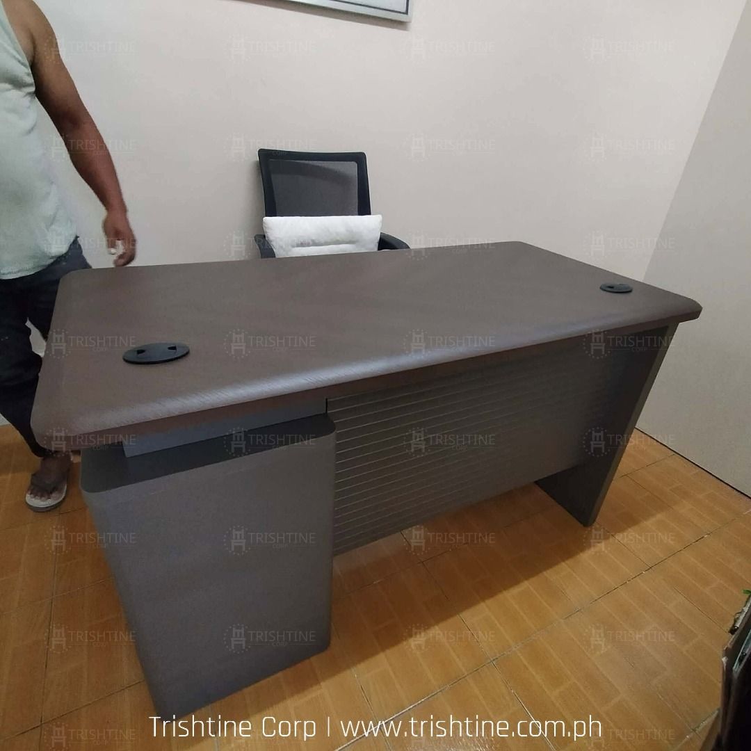 Modern Executive Office Desk with 3 Drawers (Category: Office Furniture & Fixtures) located in Caloocan City. Submitted by jim.trishtineofficefurnitures (Listing ID 1467887588, Image 2). Description: - Sturdy executive office desk in a sleek dark wood finish - Built-in 3-drawer cabinet with key lock for secure storage - Two black cable grommets on the desktop for neat wire management - Clean lines and a spacious surface area for maximum productiv