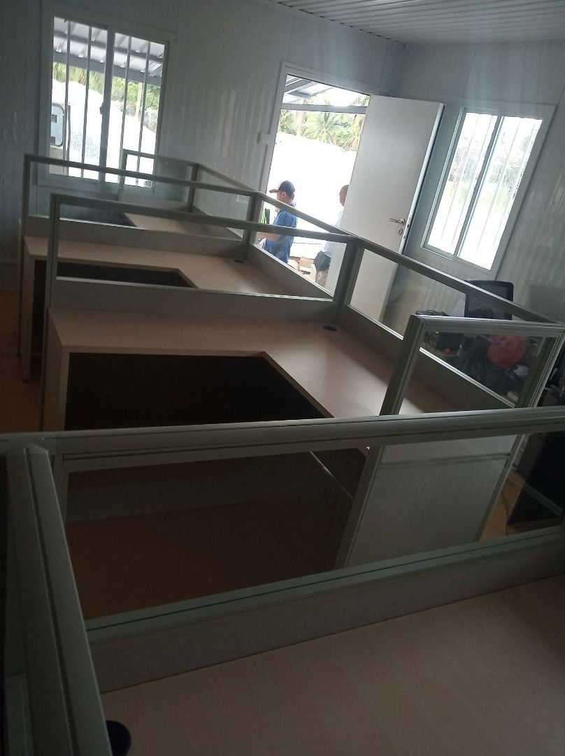 Modular Office Cubicle Partitions with Desks (Category: Office Furniture & Fixtures) located in Caloocan City. Submitted by jim.trishtineofficefurnitures (Listing ID 1467897549, Image 3). Description: - Modular office partitions with built-in desks - Light grey panel walls with clear glass top sections - Light wood grain laminate desktop surfaces - Sturdy aluminum frames for lasting durability - Ideal for call centers and open-plan office setups 