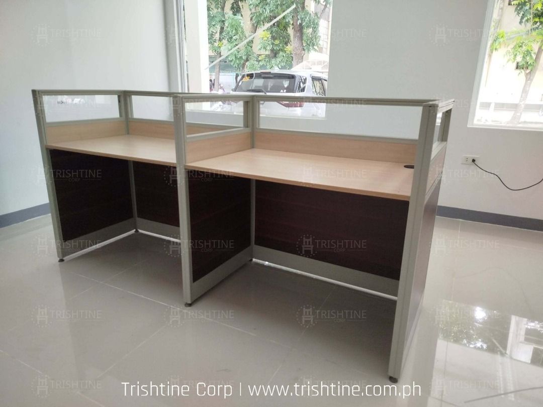 Modular Office Cubicle Workstation L-Shape Desk Partition (Category: Office Furniture & Fixtures) located in Caloocan City. Submitted by jim.trishtineofficefurnitures (Listing ID 1467896041, Image 1). Description: - Modular L-shaped office workstation set - Wooden desktops with dark brown lower panels - Modern glass top dividers - Durable aluminium frames throughout - Built-in cable management grommets - Perfect for team seating and open office l