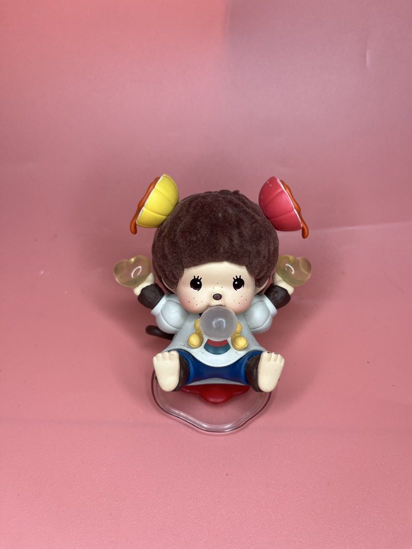 Monchhichi Art Toy Figurine Bubble Gum (Category: Designer & Blind Box Toys) located in Caloocan City. Submitted by snapshop_ph (Listing ID 1468055596, Image 1). Description: - Authentic Monchhichi collectible figure in excellent, clean condition - Features a charming monkey blowing a bubble gum bubble with colorful hair accessories - Wears a cute white and blue outfit with yellow buttons, holding yellow hearts in both hands - Surface is free fro
