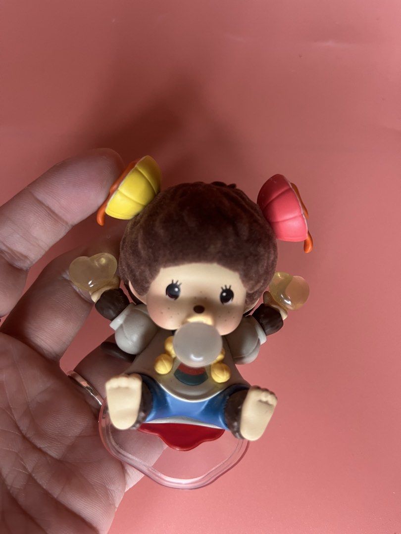 Monchhichi Art Toy Figurine Bubble Gum (Category: Designer & Blind Box Toys) located in Caloocan City. Submitted by snapshop_ph (Listing ID 1468055596, Image 2). Description: - Authentic Monchhichi collectible figure in excellent, clean condition - Features a charming monkey blowing a bubble gum bubble with colorful hair accessories - Wears a cute white and blue outfit with yellow buttons, holding yellow hearts in both hands - Surface is free fro