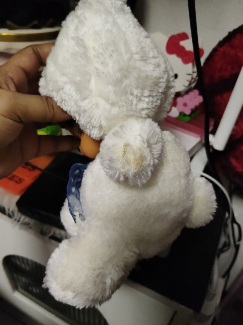 Monchhichi Bunny Plush Doll White with Blue Bow (Category: Plushies & Soft Toys) located in Pasay City. Submitted by ynamariie (Listing ID 1467909405, Image 2). Description: - Adorable 7-inch Monchhichi plush doll - Wears a sweet white bunny hood with a blue polka dot ribbon bow - Features signature brown hair, freckled face, and soft white fur - Flaw note: Minor glue stain on the back of the hood (visible in photos)(missing both hands) - Perfect