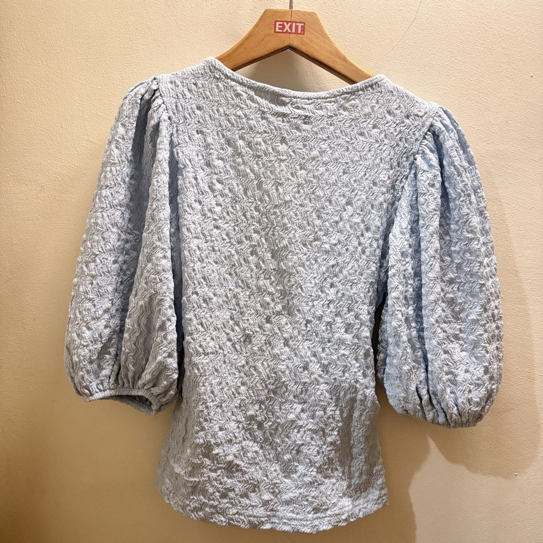 Monki light blue wrap blouse XXS textured fabric (Category: Blouses) located in Muntinlupa City. Submitted by lovedbyapril (Listing ID 1467923135, Image 2). Description: - Brand/Item: Monki wrap top - Color/Fabric: Pale blue textured fabric with stretch - Size: XS, Small to Medium - Details: V-neck, puff sleeves, adjustable waist tie - Origin: Made in Turkey - Styling: Perfect to pair with high-waisted jeans or skirts.
