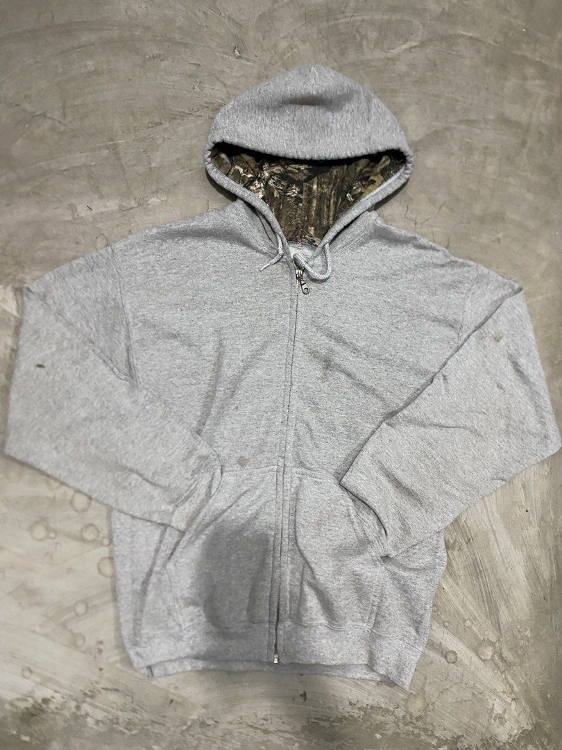 Mossy Oak Camo Lined Grey Zip Realtree (Category: Coats, Jackets and Outerwear) located in Las Pinas. Submitted by 2fly.margiela (Listing ID 1467870546, Image 1). Description: - Brand: Mossy Oak - Size: Medium - Color: Grey with camo-lined hood - Material: Cotton blend - Features: Full zip-up closure, drawstring hood, and front kangaroo pockets - Fit: Standard fit, perfect for casual wear and cooler days - Condition: Excellent.