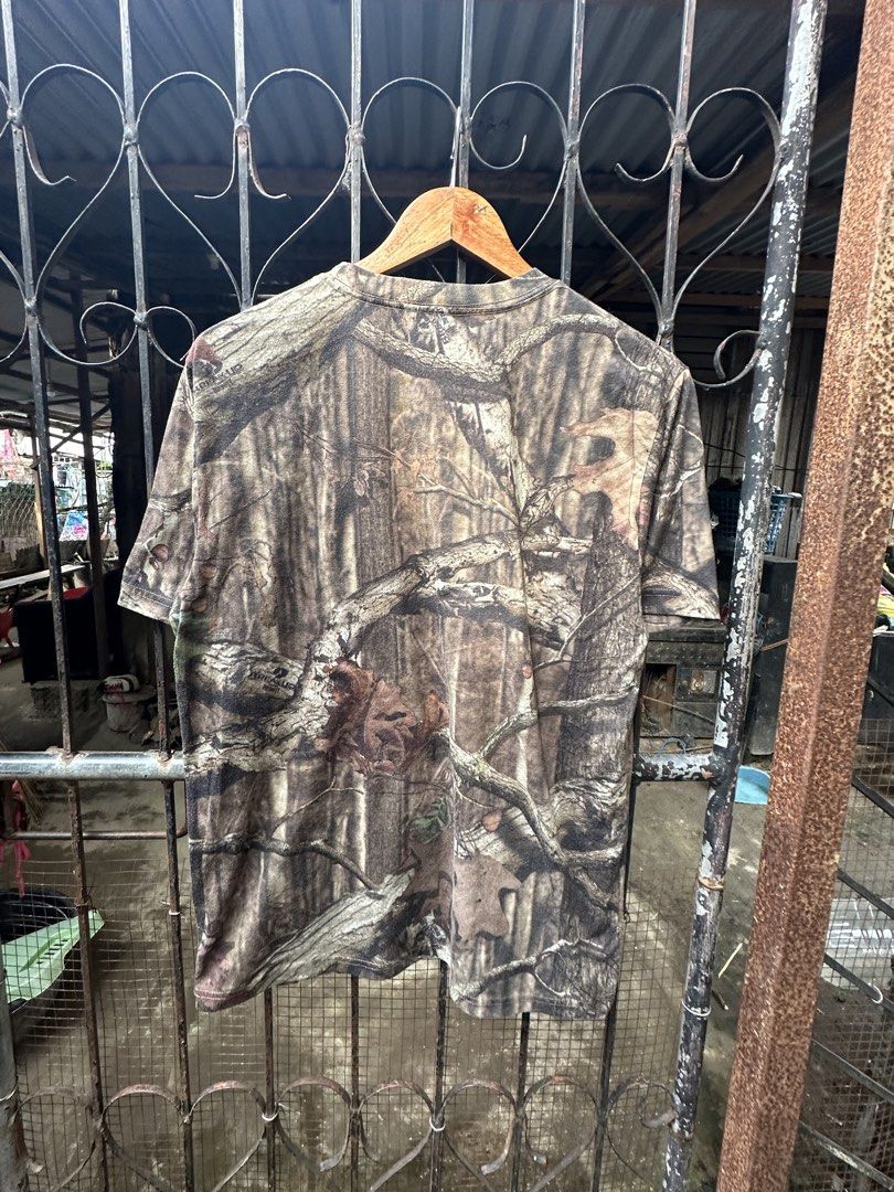 Mossy Oak Camo T-Shirt Break-Up Pattern (Category: Tshirts & Polo Shirts ) located in Lapu Lapu. Submitted by gabocamaon03138 (Listing ID 1468024700, Image 3). Description: - Brand: Mossy Oak - Design: Classic tree branch and leaf camo print - Detail: Bright yellow chest logo with vintage cracking - Style: Short sleeves, crew neck - Material: Soft, broken-in cotton blend - Condition: Great pre-loved condition, super comfortable - Perfect for outd