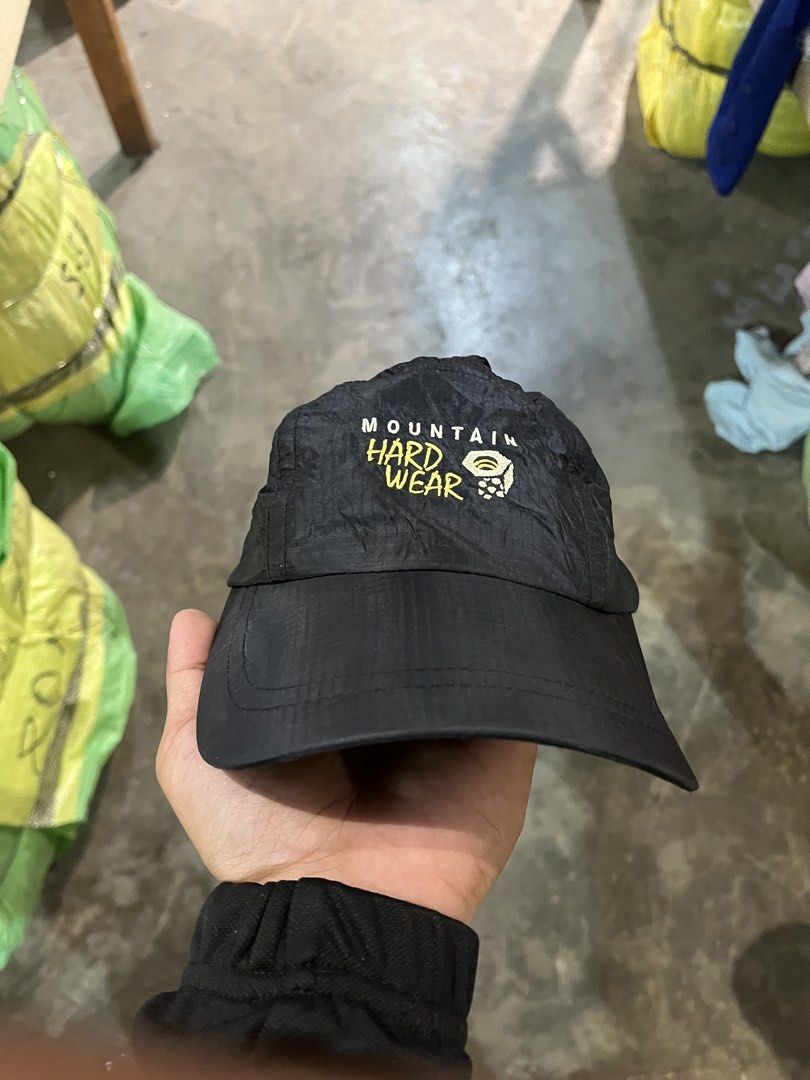 Mountain Hardwear Black Cap (Category: Caps & Hats) located in Valencia. Submitted by thriftyfinds01 (Listing ID 1468016371, Image 1). Description: - Brand: Mountain Hardwear - Color: Classic black with yellow embroidered logo on front and back - Material: Lightweight nylon with comfortable inner mesh lining - Closure: Adjustable strapback with secure plastic buckle - Condition: Great piece, complete with interior brand tags - Ideal For: Outdoor 