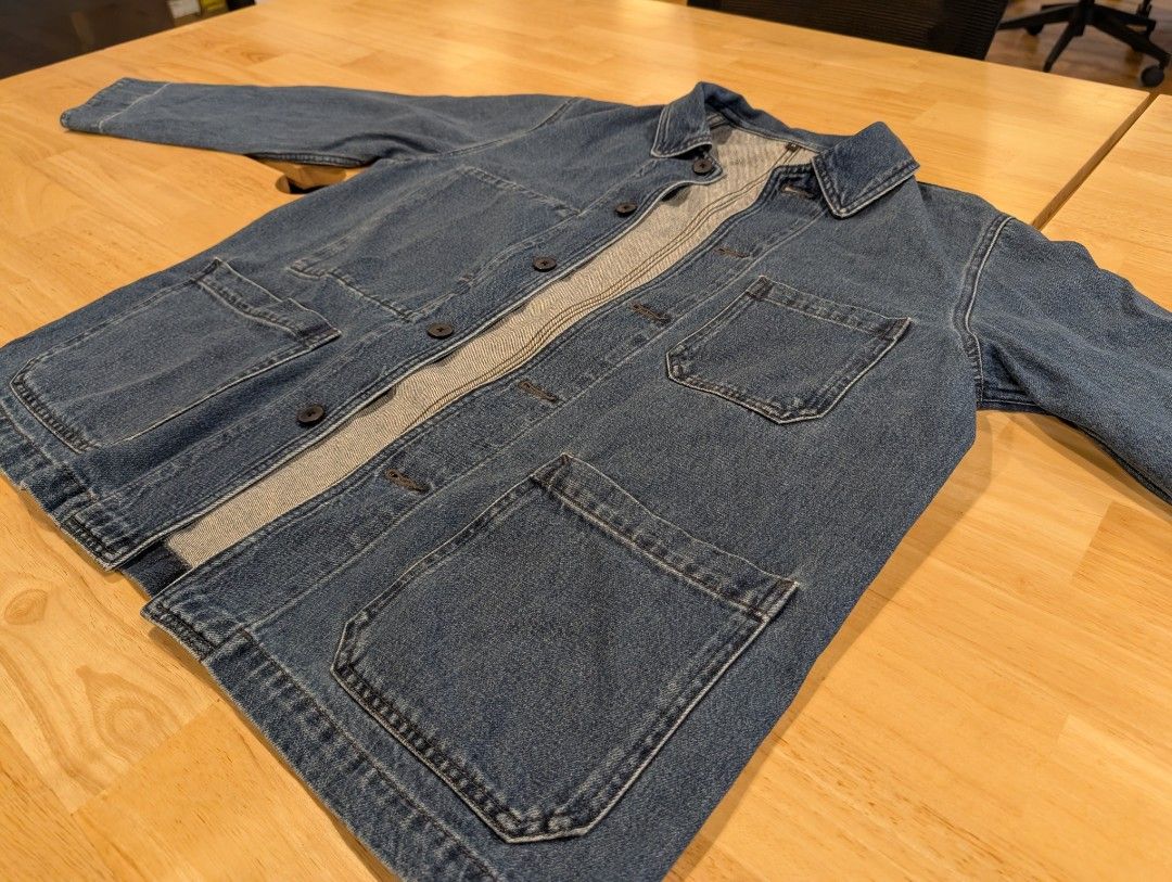 Muji Kapok blended denim jacket (Category: Coats, Jackets and Outerwear) located in Santa Cruz. Submitted by briangriffin (Listing ID 1467879471, Image 3). Description: - Size: Medium - Color: Classic Blue - Material: Durable denim - Design: Button-up front with dark buttons and structured collar - Storage: Multiple utility pockets on chest and lower front - Fit: Straight fit, ideal for layering casual outfits.