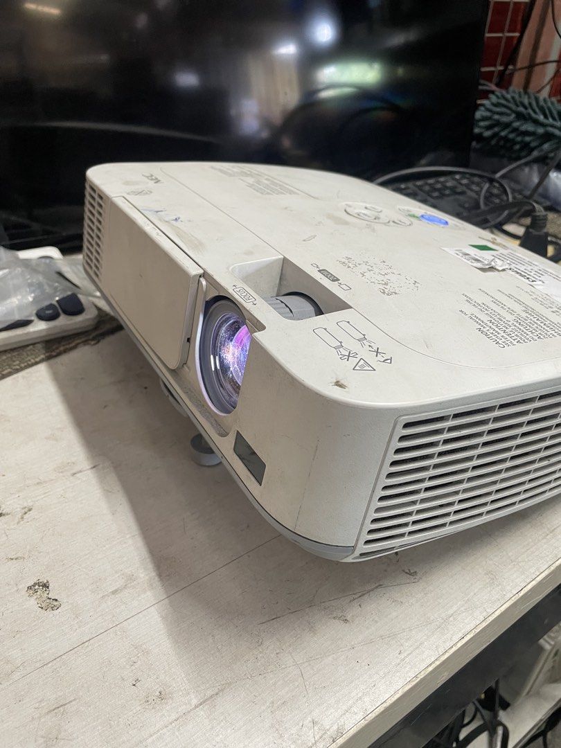 NEC M271X Projector (Category: Projectors) located in Calamba. Submitted by jozamvibar76665 (Listing ID 1467862637, Image 1). Description: - Model: NEC Projector M271X - Condition: Fully working and tested (great for sports and movies) - Ports: HDMI, Computer 1 & 2, USB, and LAN - Appearance: Clean lens, with minor dust and smudges on the white casing from normal use - Status: Powers on with a blue indicator light.