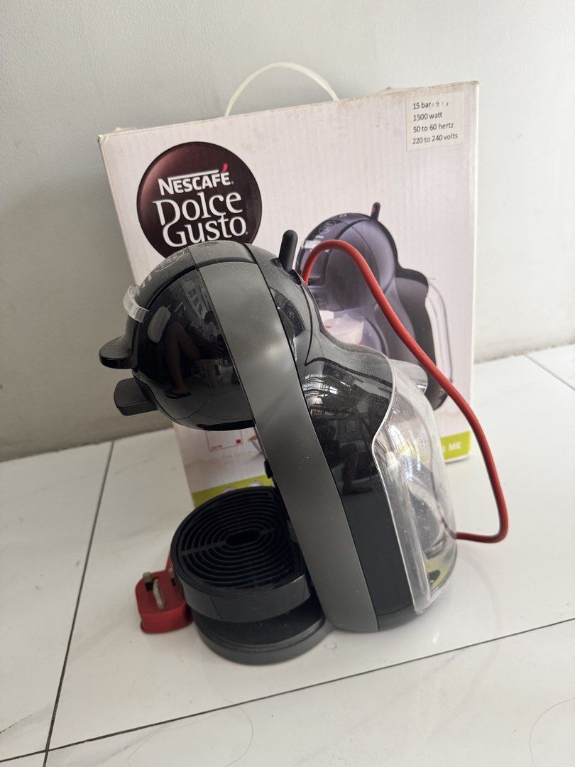 Nescafe Dolce Gusto coffee Machine (Category: Coffee Machines & Makers) located in Pasig City. Submitted by ponyo_ph (Listing ID 1467872058, Image 2). Description: - Model: Nescafe Dolce Gusto Mini Me (Black & Grey) - Condition: Comes with original box - Performance: 15-bar pump pressure, 1500 watts (220-240V) - Power: Red cord with UK 3-pin plug - Bonus: Includes a black wire capsule holder tower loaded with coffee pods - Design: Compact and spa