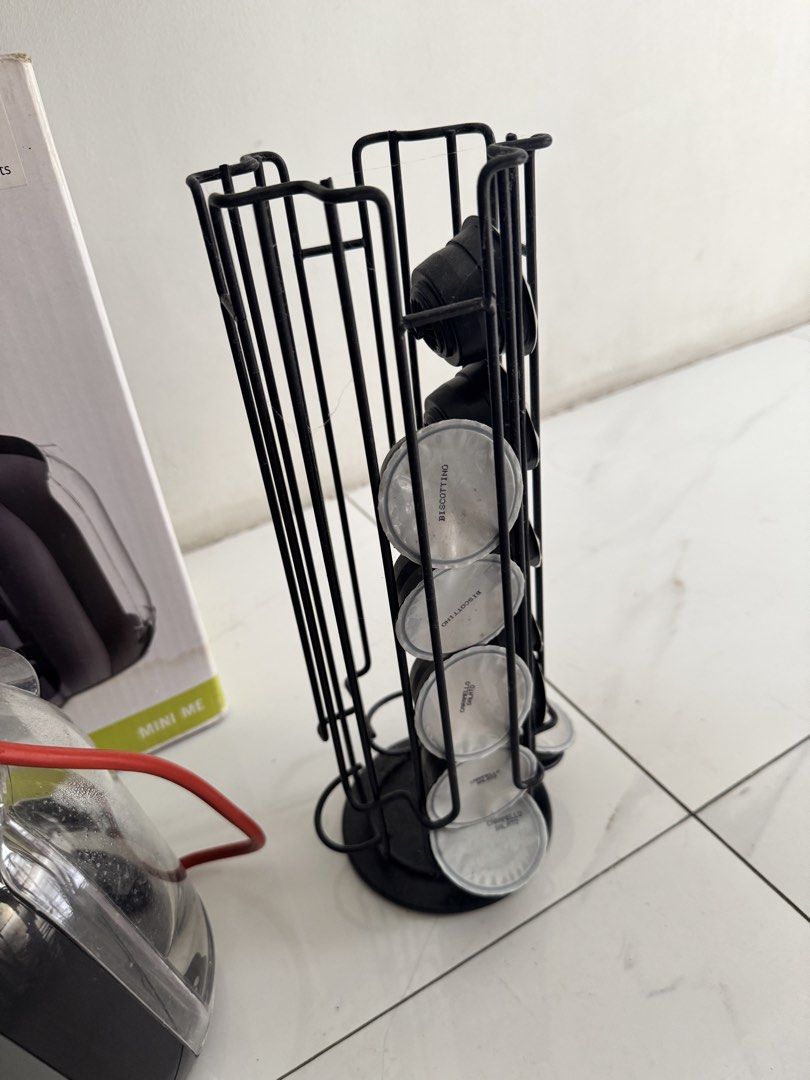 Nescafe Dolce Gusto coffee Machine (Category: Coffee Machines & Makers) located in Pasig City. Submitted by ponyo_ph (Listing ID 1467872058, Image 3). Description: - Model: Nescafe Dolce Gusto Mini Me (Black & Grey) - Condition: Comes with original box - Performance: 15-bar pump pressure, 1500 watts (220-240V) - Power: Red cord with UK 3-pin plug - Bonus: Includes a black wire capsule holder tower loaded with coffee pods - Design: Compact and spa