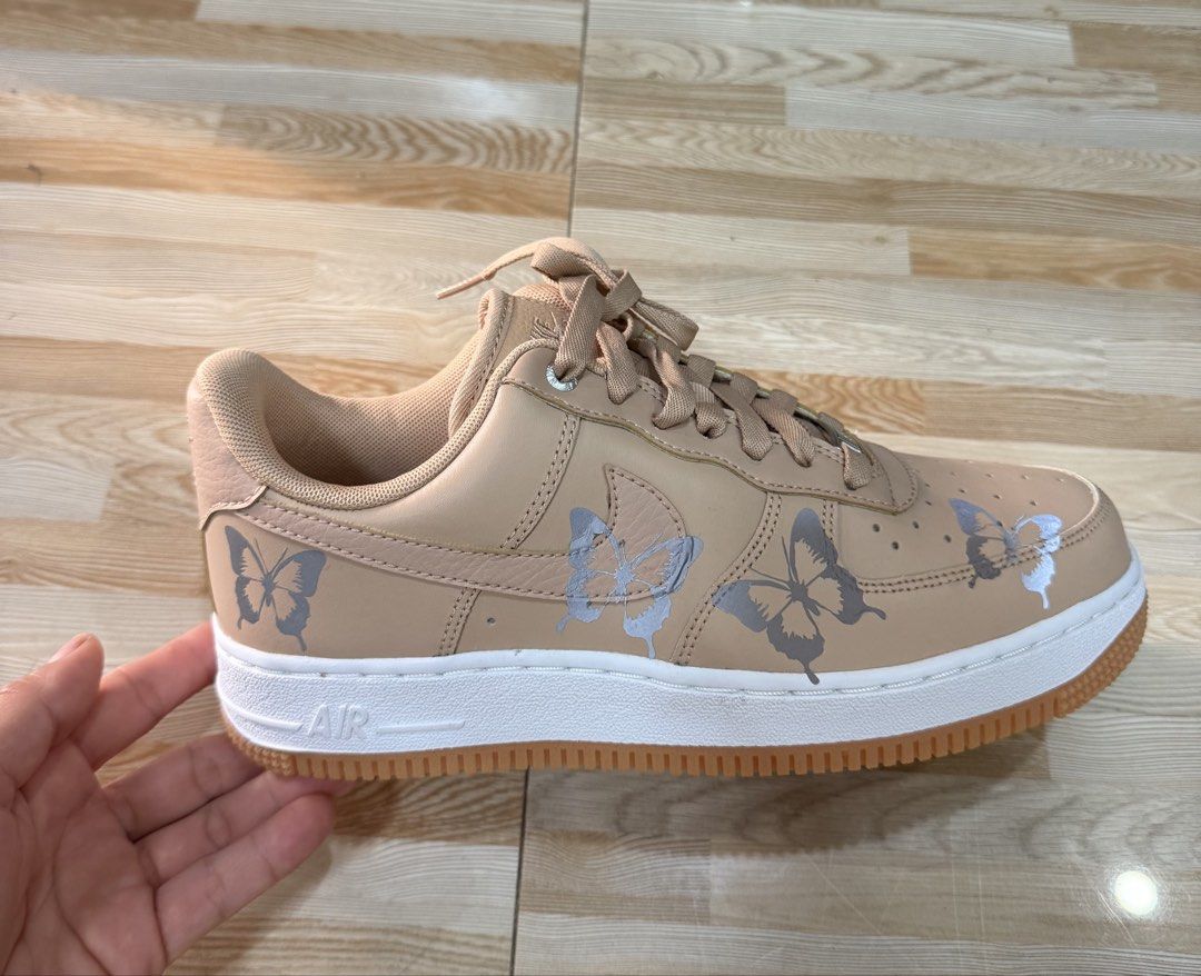 Nike Air Force 1 Butterfly Custom Sneakers (Category: Sneakers) located in Tabuk. Submitted by farawayluxe (Listing ID 1468043891, Image 1). Description: - Model: Custom Nike Air Force 1 - Colorway: Tan with white midsoles and gum outsoles - Details: grey and silver butterfly graphics stickers on sides - Hardware: Traditional lace-up closure with metallic AF1 lace dubraes - Inclusion: Original box included - Condition: Brand new / Custom art.