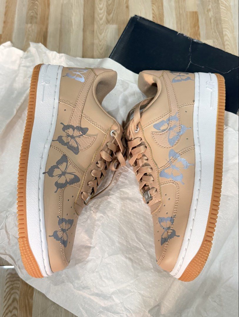 Nike Air Force 1 Butterfly Custom Sneakers (Category: Sneakers) located in Tabuk. Submitted by farawayluxe (Listing ID 1468043891, Image 3). Description: - Model: Custom Nike Air Force 1 - Colorway: Tan with white midsoles and gum outsoles - Details: grey and silver butterfly graphics stickers on sides - Hardware: Traditional lace-up closure with metallic AF1 lace dubraes - Inclusion: Original box included - Condition: Brand new / Custom art.