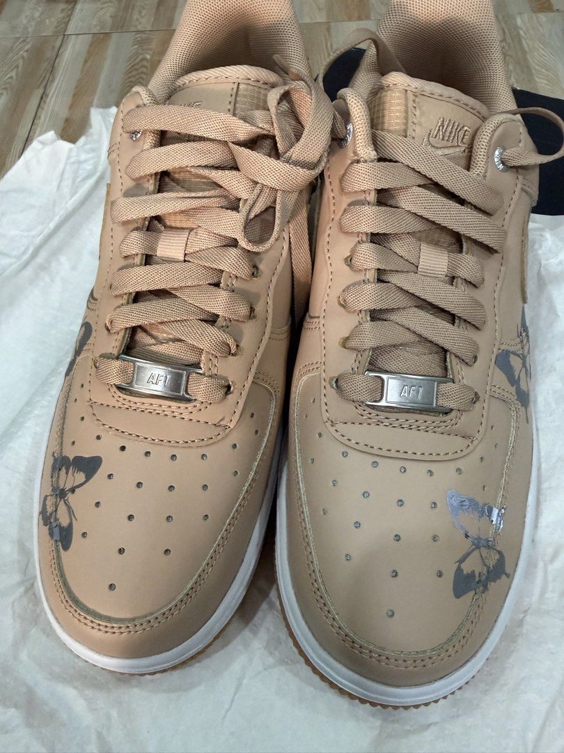 Nike Air Force 1 Butterfly Custom Sneakers (Category: Sneakers) located in Tabuk. Submitted by farawayluxe (Listing ID 1468043891, Image 2). Description: - Model: Custom Nike Air Force 1 - Colorway: Tan with white midsoles and gum outsoles - Details: grey and silver butterfly graphics stickers on sides - Hardware: Traditional lace-up closure with metallic AF1 lace dubraes - Inclusion: Original box included - Condition: Brand new / Custom art.