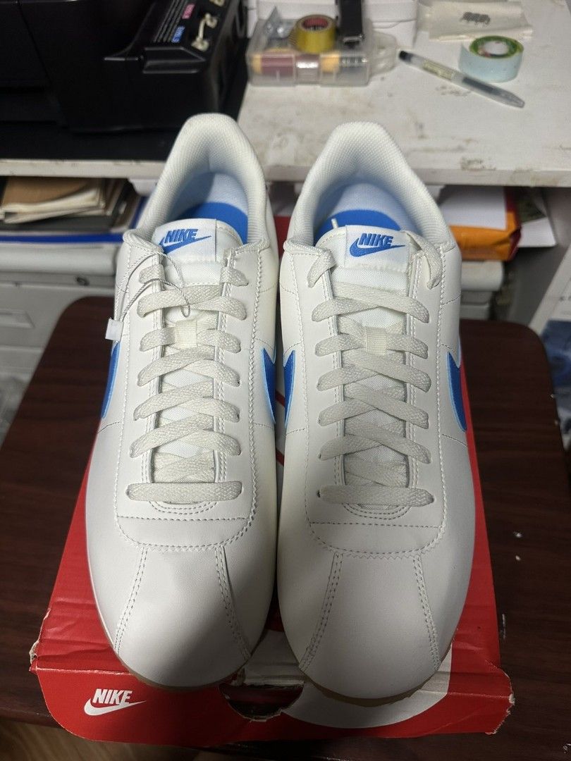 Nike Cortez (Category: Sneakers) located in Quezon City. Submitted by tikboydabigboy.tikboydabigboy (Listing ID 1467886775, Image 3). Description: - Brand: Nike - Color: White with blue swoosh and accents - Sole: Classic serrat - Details: Lace-up closure with Nike branding on the tongue - Packaging: Includes original red Nike shoe box - Condition:Brand New.