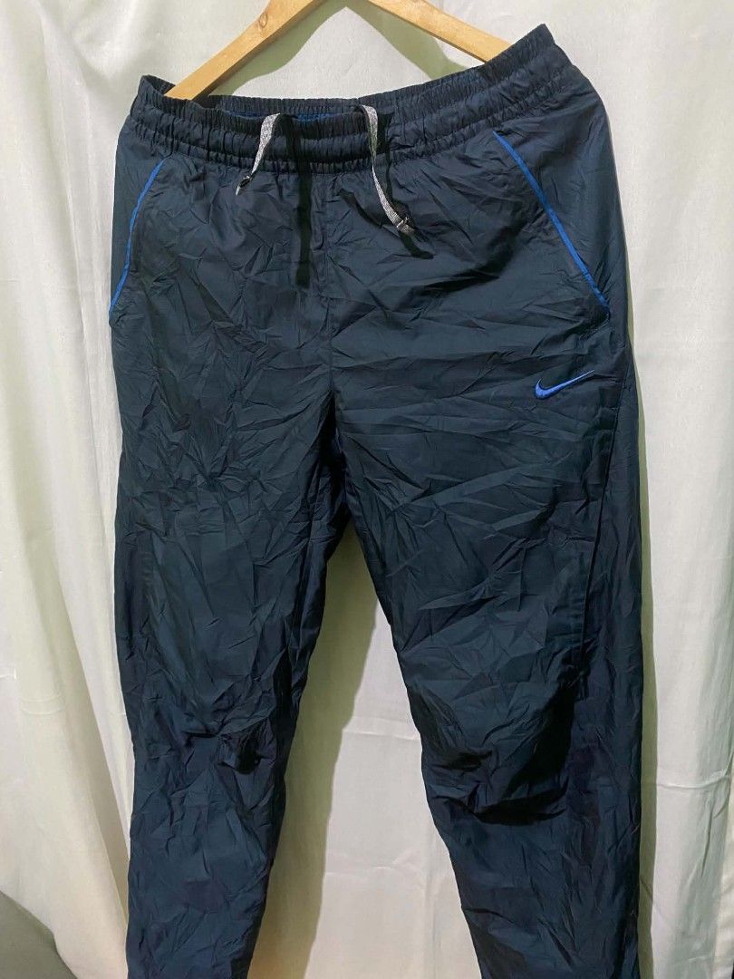 Nike Fit Storm Windrunner Pants Navy Blue Size M (Category: Joggers) located in Quezon City. Submitted by elihur.tuazon (Listing ID 1467841127, Image 2). Description: - Brand: Nike Fit Storm - Color: Navy blue with blue accents - Size: Medium (tags intact) - Material/Lining: Comfortable mesh lining inside - Features: Drawstring elastic waist, secure back zip pocket - Origin: Made in China - Style Code: 321786-475 - Condition: Good overall conditi