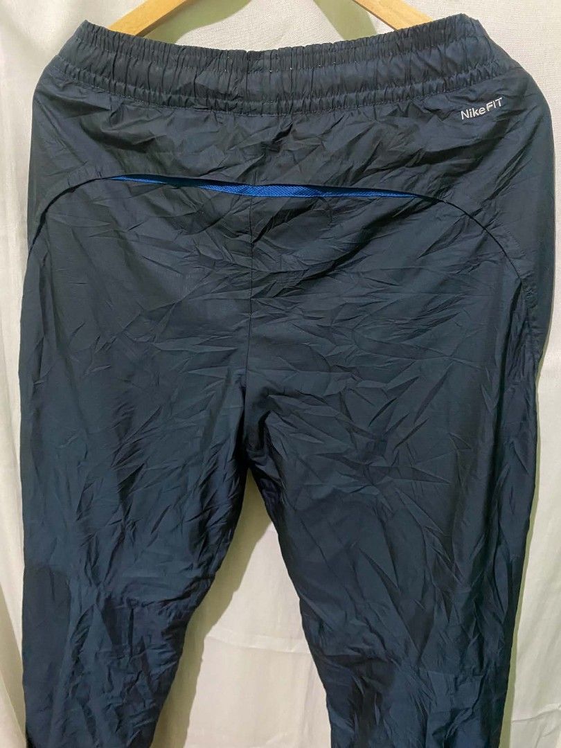 Nike Fit Storm Windrunner Pants Navy Blue Size M (Category: Joggers) located in Quezon City. Submitted by elihur.tuazon (Listing ID 1467841127, Image 3). Description: - Brand: Nike Fit Storm - Color: Navy blue with blue accents - Size: Medium (tags intact) - Material/Lining: Comfortable mesh lining inside - Features: Drawstring elastic waist, secure back zip pocket - Origin: Made in China - Style Code: 321786-475 - Condition: Good overall conditi