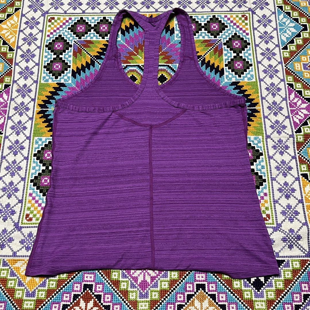 Nike Purple Racerback Workout Tank Top (Category: Activewear) located in Dagupan City. Submitted by vernzkee (Listing ID 1467864328, Image 3). Description: - Brand: Nike - Color: Purple - Style: Racerback workout tank top with textured knit fabric - Details: Classic swoosh logo near the bottom hem - Measurements: Pit to pit ~16.5 inches, Length ~24.5 inches - Condition: Clean, great for gym sessions, running, or casual wear.