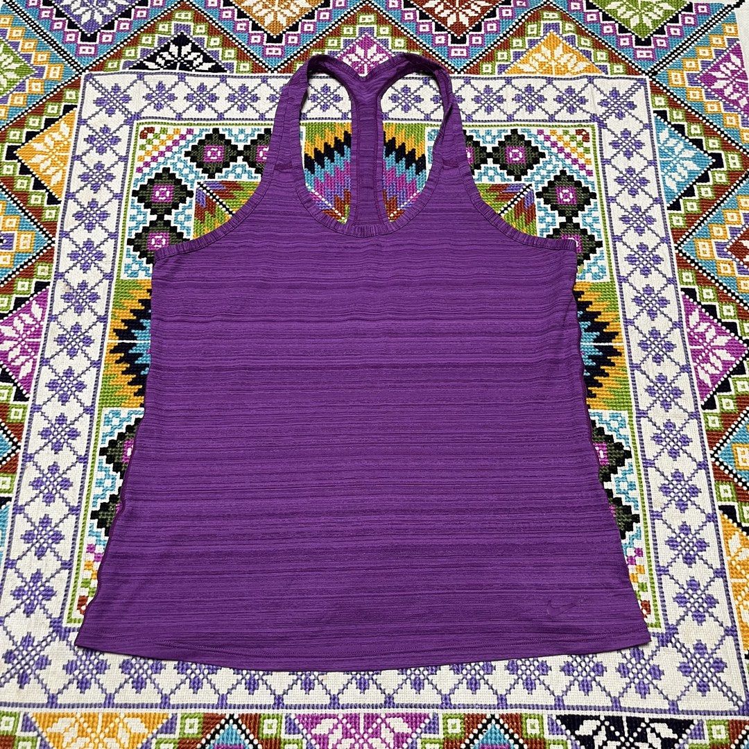 Nike Purple Racerback Workout Tank Top (Category: Activewear) located in Dagupan City. Submitted by vernzkee (Listing ID 1467864328, Image 1). Description: - Brand: Nike - Color: Purple - Style: Racerback workout tank top with textured knit fabric - Details: Classic swoosh logo near the bottom hem - Measurements: Pit to pit ~16.5 inches, Length ~24.5 inches - Condition: Clean, great for gym sessions, running, or casual wear.
