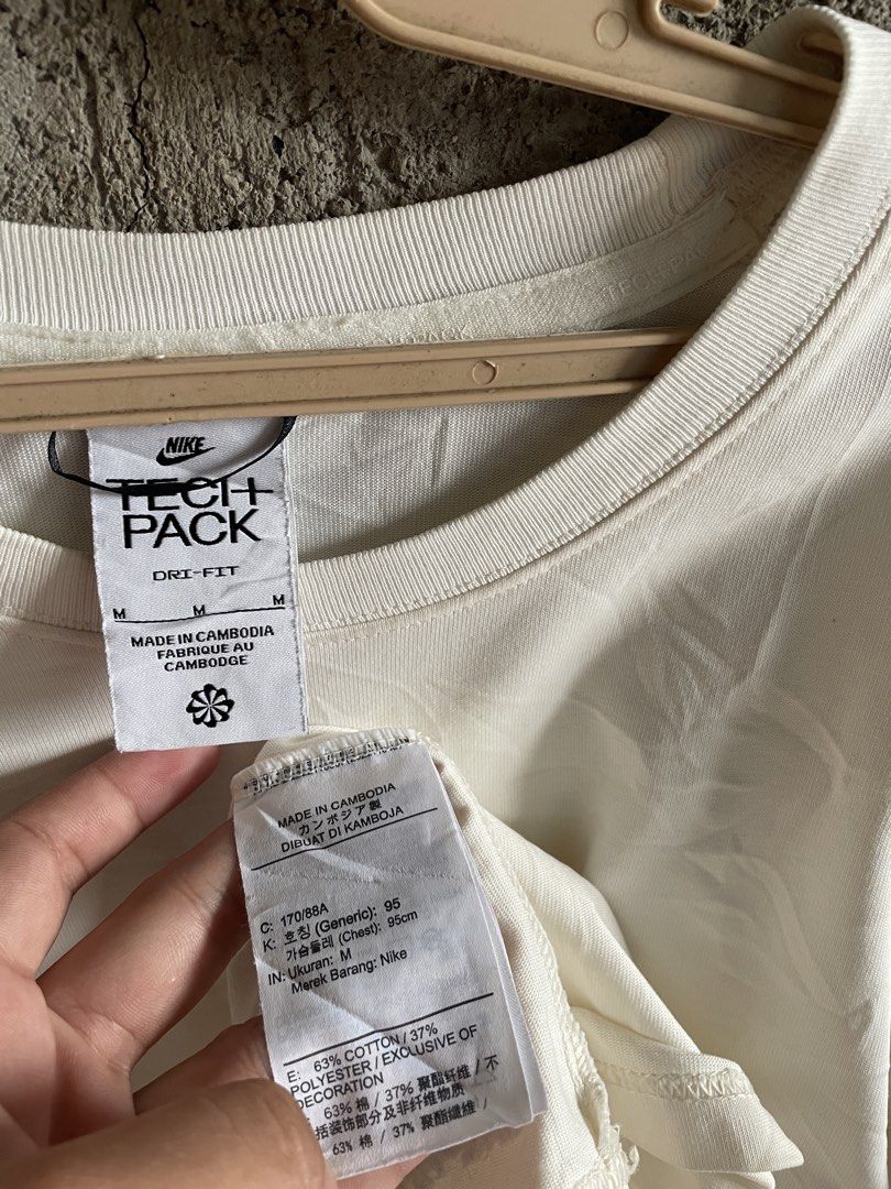 Nike Tech Pack Dri-FIT White T-Shirt Size M (Category: Tshirts & Polo Shirts ) located in Cebu City. Submitted by grand_kian (Listing ID 1467938149, Image 3). Description: - Brand: Nike Tech Pack - Color: White - Size: Medium (Relaxed fit) - Material: Cotton & polyester blend with moisture-wicking Dri-FIT technology - Design: Classic crew neck with an embroidered Nike logo and flower graphic on the left sleeve - Origin: Made in Cambodia - Conditi