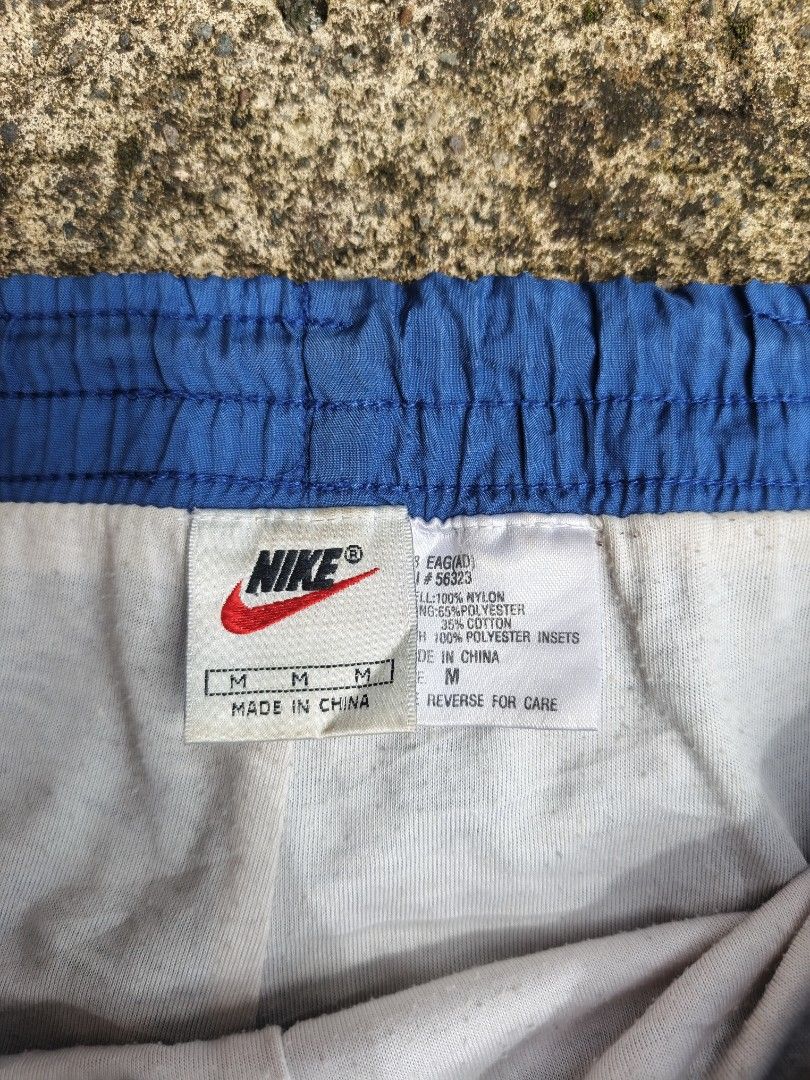 Nike Vintage Nylon Track Pants Blue (Category: Joggers) located in Manila. Submitted by gamierjohn28952 (Listing ID 1467942459, Image 3). Description: - Brand: Nike - Style: Vintage nylon track pants - Color: Blue - Size: Medium - Waist: Elastic with adjustable drawstring and inner lining - Condition: Clean overall look with a small tear near the seam (as pictured) - Material: Lightweight.