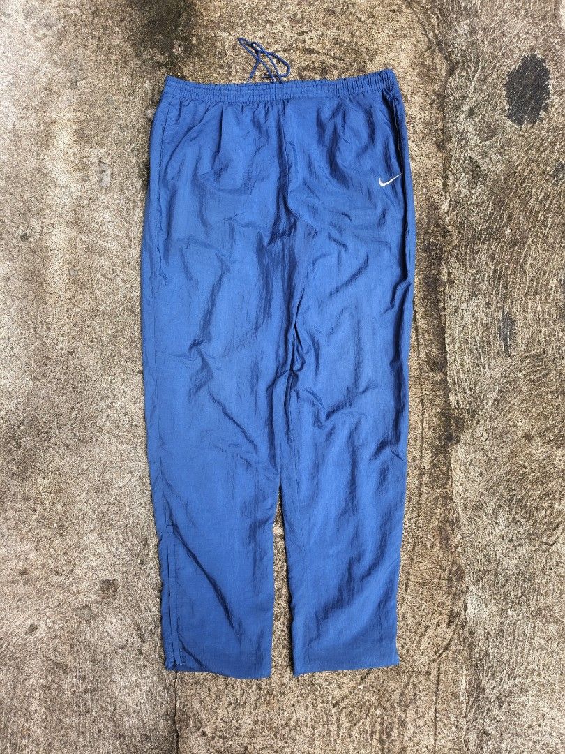 Nike Vintage Nylon Track Pants Blue (Category: Joggers) located in Manila. Submitted by gamierjohn28952 (Listing ID 1467942459, Image 1). Description: - Brand: Nike - Style: Vintage nylon track pants - Color: Blue - Size: Medium - Waist: Elastic with adjustable drawstring and inner lining - Condition: Clean overall look with a small tear near the seam (as pictured) - Material: Lightweight.