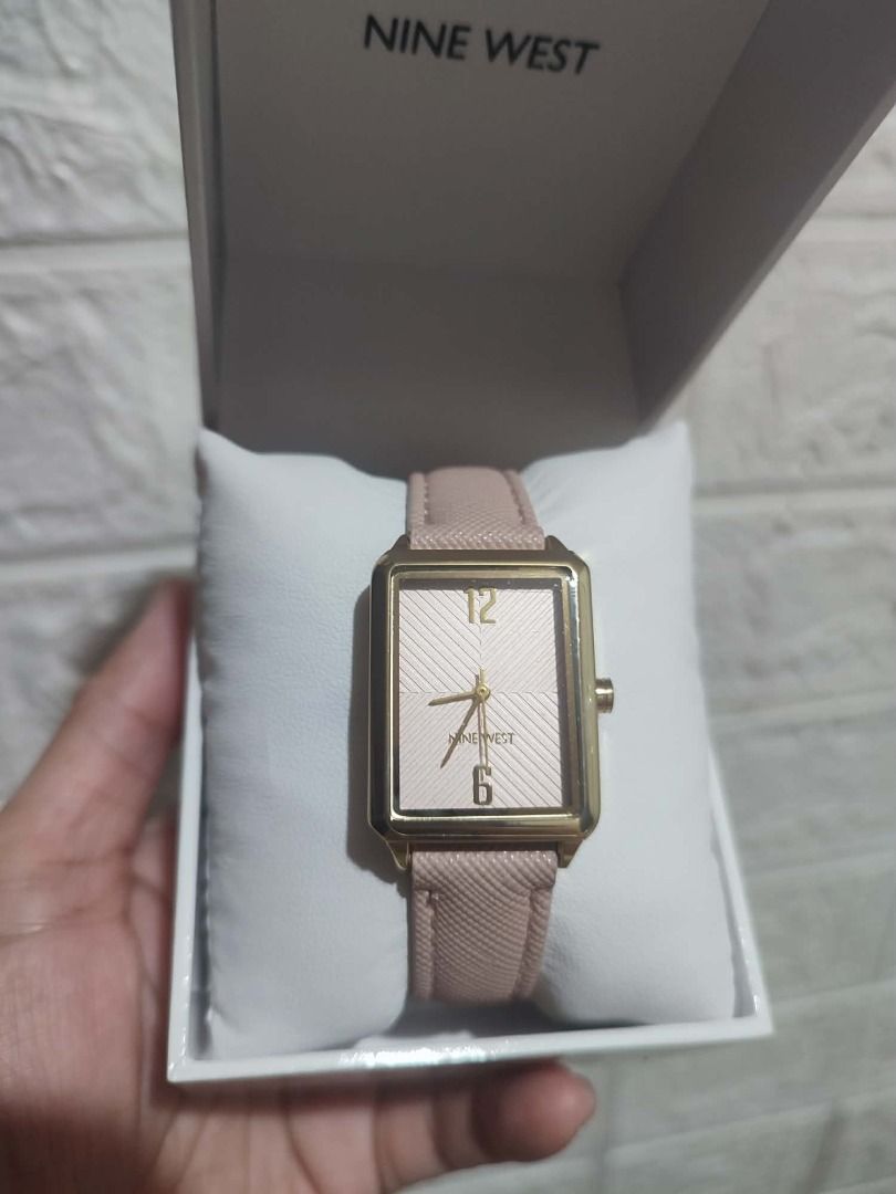 Nine West Rectangular Dial Watch with Pink Strap (Category: Women's Watches) located in Caloocan City. Submitted by jel_gielle (Listing ID 1467853790, Image 1). Description: - Brand: Nine West - Design: Rectangular gold-tone case with a striped dial pattern and gold numbers at 12 and 6 - Strap: Pink textured strap - Inclusions: Original branded white box and display pillow - Condition: Excellent, great for daily outfits and office wear.