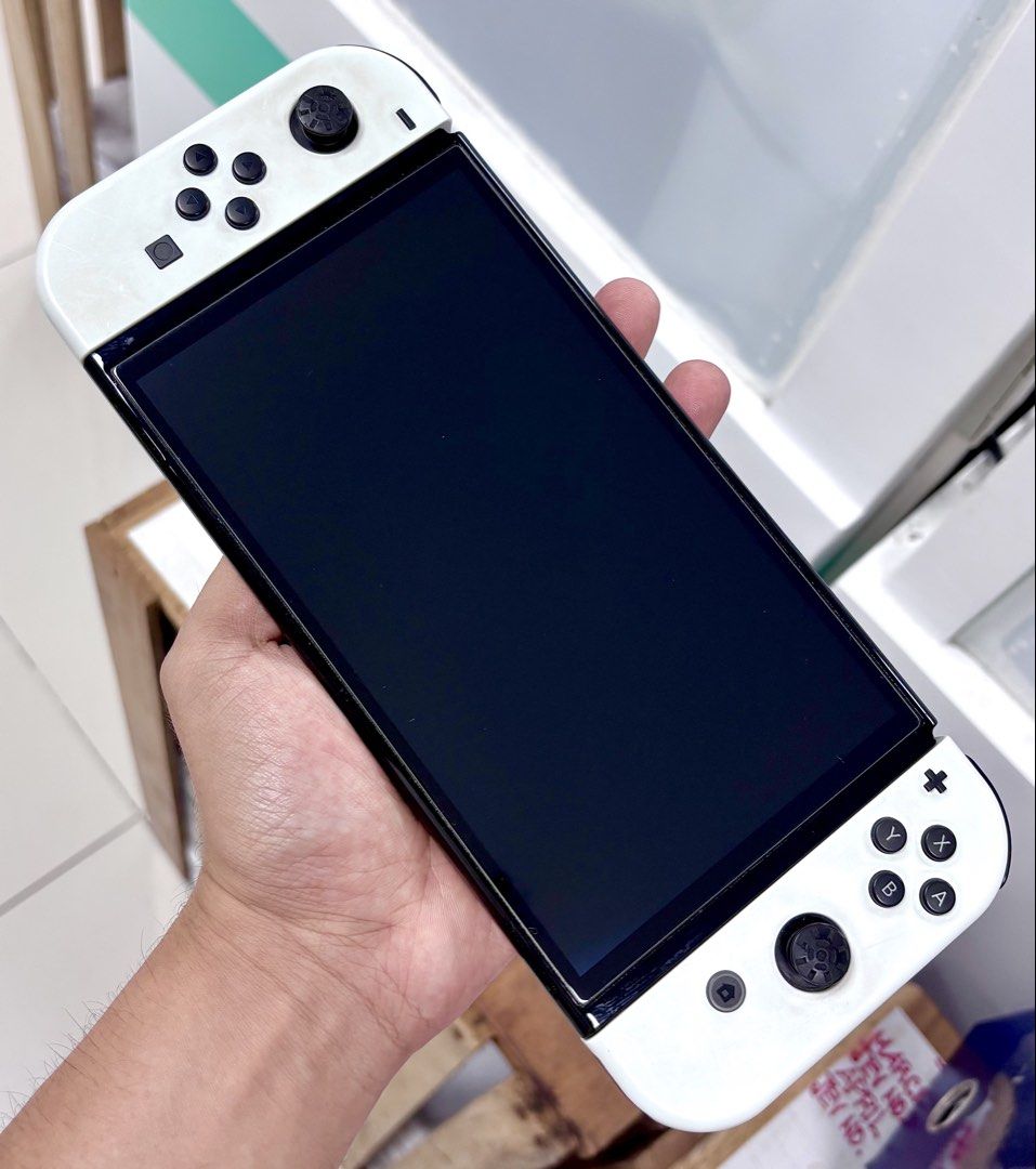 Nintendo Switch OLED (Category: Nintendo) located in Tarlac. Submitted by ggplaysph (Listing ID 1467844033, Image 2). Description: NINTENDO SWITCH OLED 💸 7,000 pesos only INCLUSIONS: ✅ Original Joy-Con Grip (worn out & has dog bite marks) ✅ Original HDMI Cable ✅ Tempered Glass Installed ❌ L button issue: only clicks on the bottom edge; top part is stiff/unclickable ❌ Both Joy-Con thumb grips peeled off ❌ No games included (sold separately) ❌ Wit