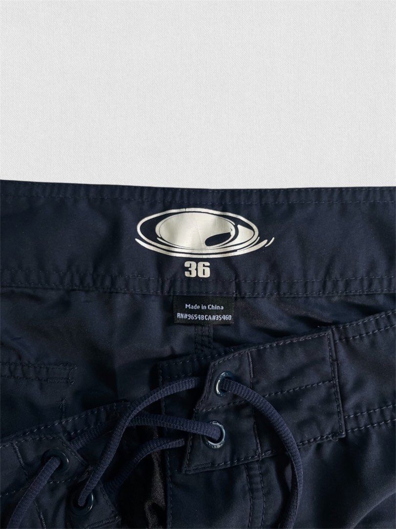Oakley Board Shorts Navy Size 36 (Category: Swim Trunks & Board Shorts) located in Cebu City. Submitted by northdrip.threadd (Listing ID 1467902605, Image 2). Description: - Brand: Oakley - Color: Navy Blue - Size: 36 (inner waistband tag) - Closure: Adjustable drawstring with reinforced eyelets - Pockets: Single back pocket with flap closure and drainage eyelet - Details: Subtle embroidered Oakley ellipse logo on the lower left leg - Condition: 