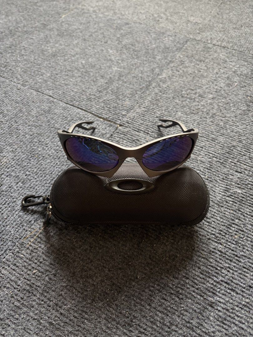 Oakley Plantaris Sunglasses (Category: Sunglasses & Eyewear) located in Manila. Submitted by toys_hats005 (Listing ID 1467960289, Image 1). Description: - Authentic Oakley sunglasses - Dark frames with striking blue reflective lenses - Unique cut-out design on the arms - Includes original Oakley black zippered hard case with carabiner hook - Condition: Clean lenses, solid frames, 100% ready to wear - Perfect for daily use or outdoor activities - 