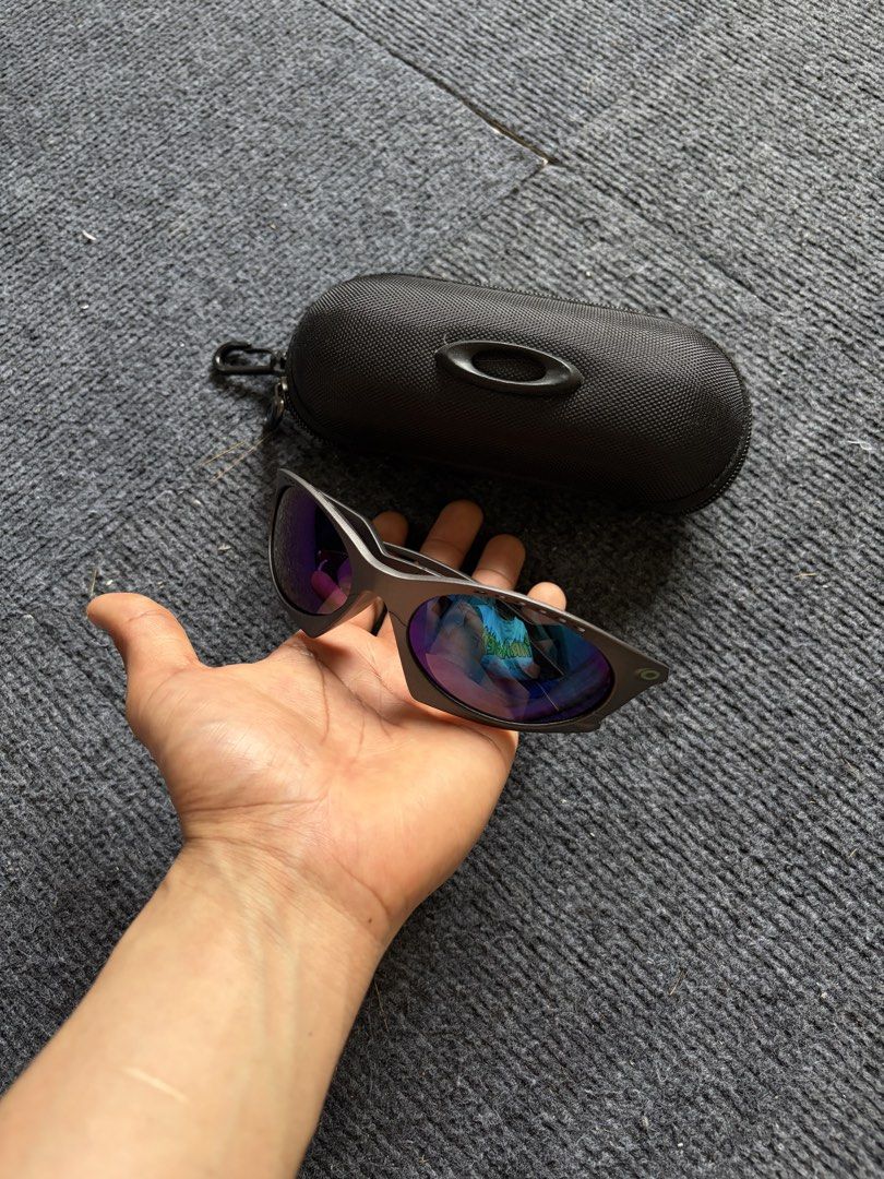 Oakley Plantaris Sunglasses (Category: Sunglasses & Eyewear) located in Manila. Submitted by toys_hats005 (Listing ID 1467960289, Image 3). Description: - Authentic Oakley sunglasses - Dark frames with striking blue reflective lenses - Unique cut-out design on the arms - Includes original Oakley black zippered hard case with carabiner hook - Condition: Clean lenses, solid frames, 100% ready to wear - Perfect for daily use or outdoor activities - 