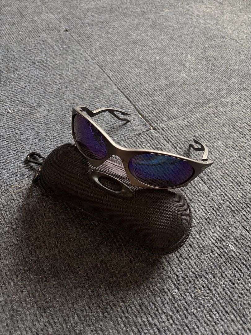 Oakley Plantaris Sunglasses (Category: Sunglasses & Eyewear) located in Manila. Submitted by toys_hats005 (Listing ID 1467960289, Image 2). Description: - Authentic Oakley sunglasses - Dark frames with striking blue reflective lenses - Unique cut-out design on the arms - Includes original Oakley black zippered hard case with carabiner hook - Condition: Clean lenses, solid frames, 100% ready to wear - Perfect for daily use or outdoor activities - 