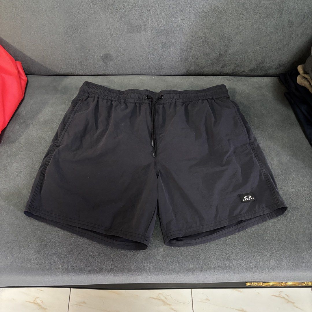 Oakley short (Category: Swim Trunks & Board Shorts) located in San Fernando. Submitted by diff.thr1ft (Listing ID 1467864293, Image 1). Description: - Brand: Oakley - Color: Black - Size: US/EU M / JPN L (Regular Fit) - Features: Elastic waistband with adjustable branded drawstrings and Oakley logo patch on the hem - Condition: Excellent pre-loved condition - Ideal for: Casual wear, swimming, and outdoor activities.