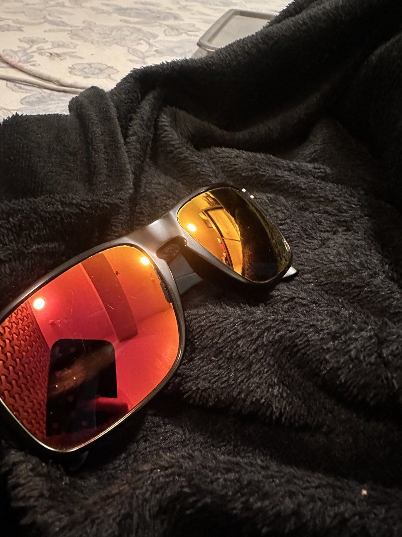 Oakley Sunglasses Red Mirror Lenses Matte Black Frame (Category: Sunglasses & Eyewear) located in Mandaluyong City. Submitted by enyaj_11 (Listing ID 1468004110, Image 1). Description: - Brand: Oakley sunglasses - Frame: Matte black with classic square shape - Lenses: Striking red mirror lenses - Details: Iconic red O-logo icons on the temples - Condition: Fully functional; note noticeable wear and flaking along the inner edge of the right lens n