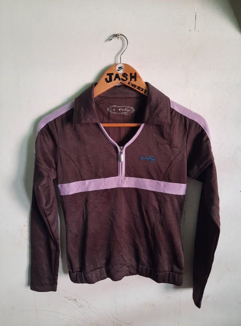 Oakley Vintage Quarter Zip Pullover Brown Purple (Category: Coats, Jackets and Outerwear) located in City of Isabela. Submitted by jasheverything (Listing ID 1467942113, Image 1). Description: - Brand: Oakley - Style: Quarter-zip pullover with collared neckline - Size: Small - Color: Brown and purple with contrast purple piping and midsection band - Logo: Bright blue embroidered Oakley logo on the chest - Material/Texture: Striped ribbed fabric t