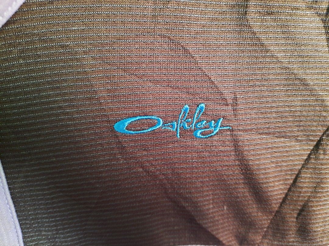 Oakley Vintage Quarter Zip Pullover Brown Purple (Category: Coats, Jackets and Outerwear) located in City of Isabela. Submitted by jasheverything (Listing ID 1467942113, Image 3). Description: - Brand: Oakley - Style: Quarter-zip pullover with collared neckline - Size: Small - Color: Brown and purple with contrast purple piping and midsection band - Logo: Bright blue embroidered Oakley logo on the chest - Material/Texture: Striped ribbed fabric t